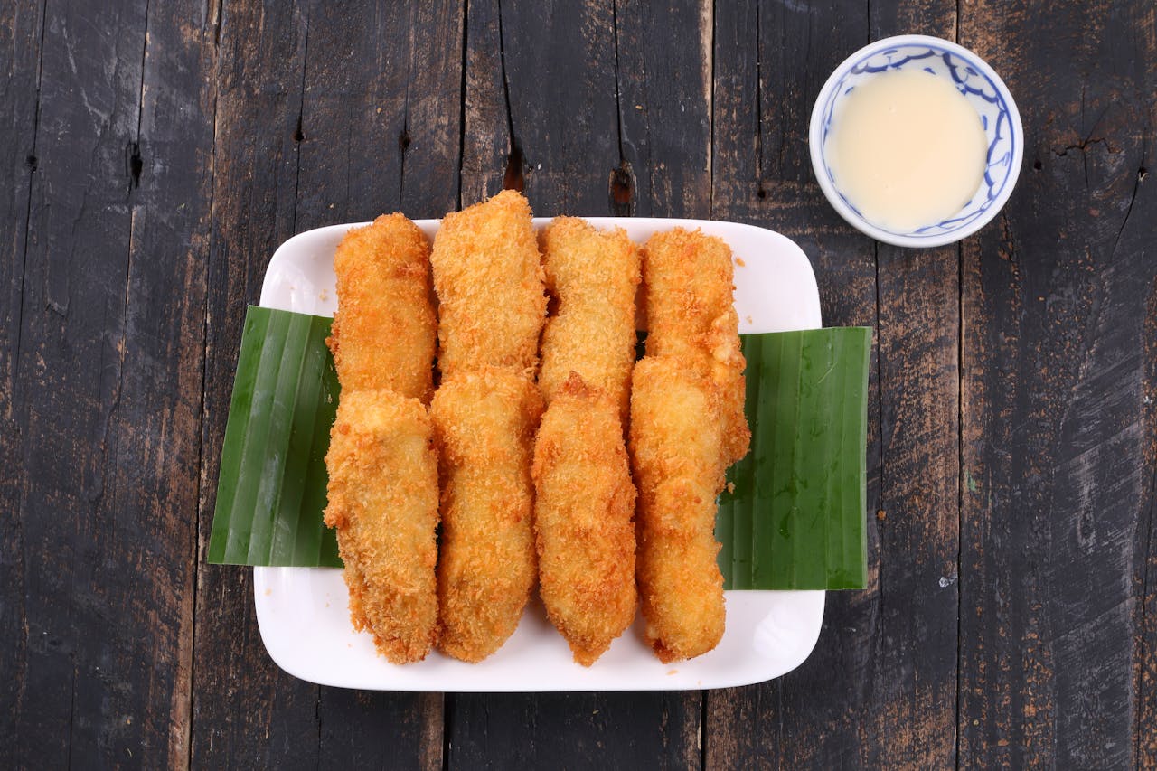 services-05 Delicious crispy fried bananas served on a plate with a sweet dipping sauce.